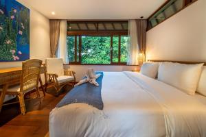 a bedroom with a large bed with a stuffed animal on it at Villa Seremi in Bedahulu +23 photos