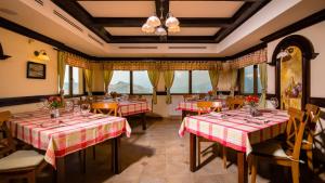 a restaurant with red and white tables and chairs at Nobillis - Carpathian Residence in Peştera
