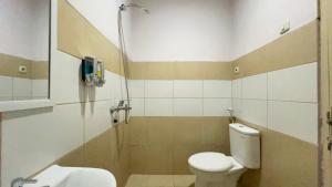 ein Badezimmer mit Toilette und Waschbecken in der Unterkunft Nira Nordic Rooms in Seturan