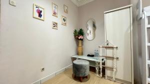 ein Ankleidezimmer mit Hocker und Spiegel in der Unterkunft Nira Nordic Rooms in Seturan