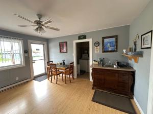 a kitchen and dining room with a table and a ceiling fan at Auberge Restwell Motel in Moncton