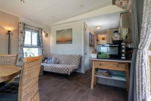 a living room with a couch and a television at Hello Zeeland - Hoge duvekotsweg 12 in Oostkapelle +9 photos