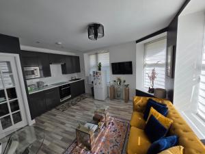 a living room with a couch and a kitchen at The Holiday 20 flat! outside LEZ in Aberdeen