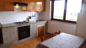 a kitchen with a table and a stove and a counter top at Casa Ardora - Playa de Carnota in San Mamede de Carnota