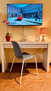 una scrivania con TV su un muro e sedia di Casa Torino Lingotto, fiere, metro, Inalpi Arena,Centro Congressi, Ospedale, Politecnico a Torino