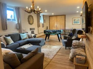 un salon avec un canapé et une table dans l'établissement Stunning Luxury Holiday Accommodation, Sleeps 4, Living Room, Kitchen, Games Room and Bar, à Mörtelsdorf