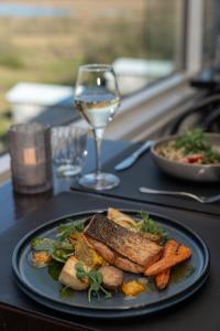 a plate of food on a table with a glass of wine at Hotel Laki in Kirkjubæjarklaustur