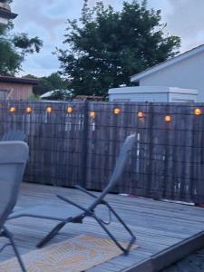 a chair in front of a fence with lights on it at Charmant logement neuf in Hourtin