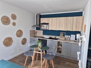a kitchen with a table and chairs in a room at Charmant logement neuf in Hourtin
