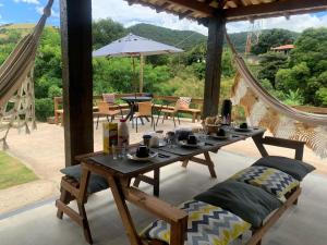 a patio with a table and chairs with a view at Refúgio Três Estações in Paty do Alferes