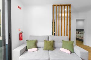 a living room with a gray couch with pink and green pillows at Casa da Guida in Machico