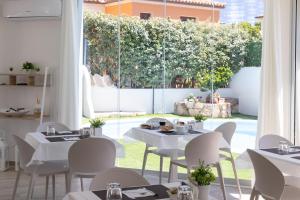 a restaurant with white tables and chairs and a large window at Seaside Home in Posada