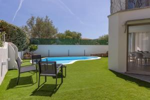 a backyard with a swimming pool and grass at Seaside Home in Posada