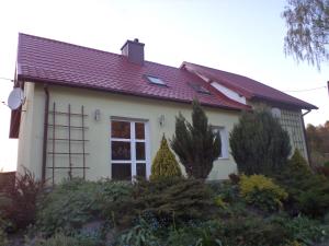 uma casa branca com um telhado vermelho em Domek pod brzozą em Mrągowo