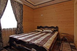 a bedroom with a bed in a wooden room at Котедж 7я in Verkhovyna