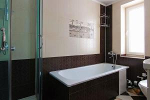 a bathroom with a bath tub and a sink at Сім'я in Verkhovyna