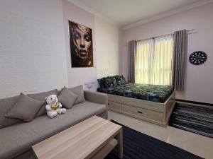 a living room with a couch and a bed at Large Studio Apartment for 4 in Sharjah