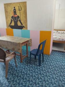 una stanza con tavolo, sedia e quadro di Johnson's Homestay With Pool & Ecohouseboat near town beach a Alleppey