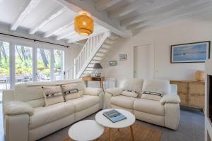 a living room with two couches and a table at Villa Capucine accès direct plage in Lège-Cap-Ferret