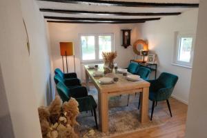 een eetkamer met een tafel en groene stoelen bij Ferienhaus Fachwerklust in der Eifel in Mechernich
