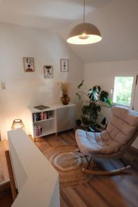 een woonkamer met een stoel en een plant bij Ferienhaus Fachwerklust in der Eifel in Mechernich