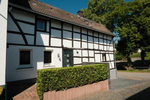 een wit en zwart huis met een groene deur bij Ferienhaus Fachwerklust in der Eifel in Mechernich