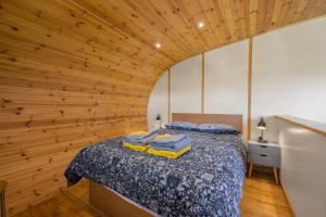 a bedroom with a bed in a room with wooden walls at Kingsdale Luxury Pod with Hot Tub at Fell View Park Kirkby Lonsdale in Kirkby Lonsdale