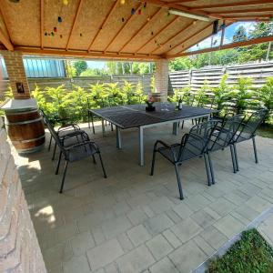 a patio with a table and chairs under a wooden roof at Villa Mátis in Balatonederics