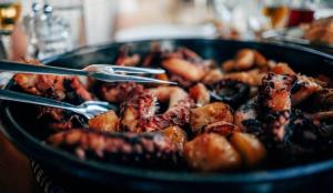 a pan full of food with tongs in it at Holiday house Anna in Veli Iž