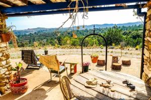 a table and chairs on a patio with a view at WILDSPIRIT Bedroom in Permaculture Paradise at WILDSPIRIT Eco Cultural Farm in Villanueva de Alcolea