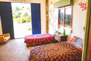 a bedroom with two beds and a large window at WILDSPIRIT Bedroom in Permaculture Paradise at WILDSPIRIT Eco Cultural Farm in Villanueva de Alcolea