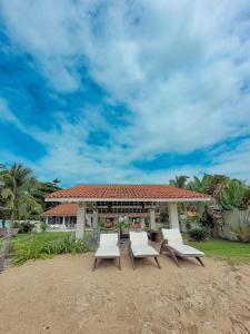 a group of chairs sitting in front of a building at Nossa Casa Maracaipe in Porto De Galinhas