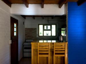 a kitchen with a stove and a counter with chairs at Cabaña Trabun Lago Puelo in Lago Puelo