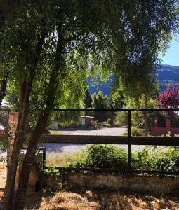 a fence next to a river with a tree at Cabaña Trabun Lago Puelo in Lago Puelo