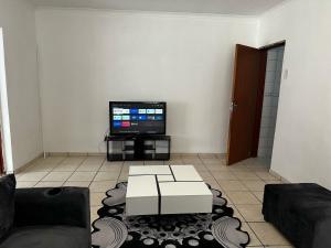 a living room with a couch and a tv at Modest Cottage in Germiston