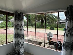 a window with curtains and a fire hydrant at Modest Cottage in Germiston