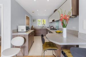 StonewoodにあるSpacious 3-Bedroom Retreat with Garden Near Bluewaterのキッチン(椅子とテーブル付きのカウンター付) +8枚の写真