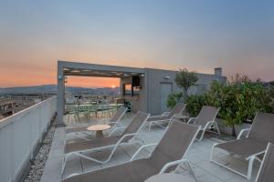 a patio with chairs and tables on a balcony at Casual Kubic Athens by Casual Hoteles in Athens
