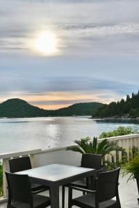 a table and chairs on a balcony overlooking a lake at Villa Ante Apartments in Blace