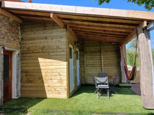 a wooden house with a hammock and a patio at gîte les 3 coquelicots bis in Coublanc