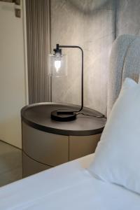 Una mesa con una luz al lado de una cama. en 2BR Aljada heaven by BlueCloud Holidays, en Sharjah
