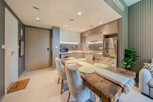Una cocina y un comedor con mesa y sillas de madera. en 2BR Aljada heaven by BlueCloud Holidays, en Sharjah