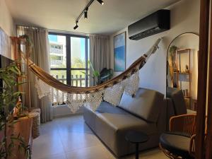 a hammock in a living room with a couch at Refúgio Maracatiara in Luis Correia