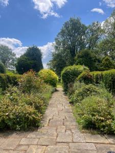 a stone path through a garden with bushes at Gallows Hill in Scarborough