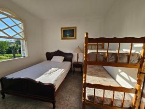 ein Schlafzimmer mit zwei Etagenbetten und einem Fenster in der Unterkunft Sítio à beira da represa in Nazaré Paulista