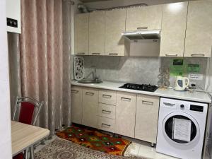 a kitchen with a stove and a washing machine at Lime Apart Hotel in Bukhara