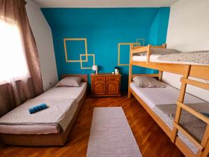 two bunk beds in a room with a blue wall at Amrita Guesthouse in Mostar