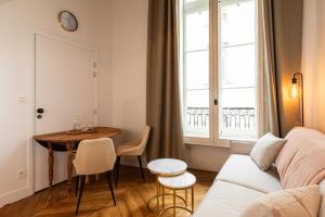 a living room with a couch and a table and a window at SmartStay Traboule - Place Bellecour in Lyon