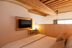 a bedroom with a bed and a tv on the wall at SmartStay Traboule - Place Bellecour in Lyon