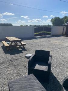 a picnic table and a bench next to a picnic table and a picnic table at Maison calme à la campagne in Cléré-les-Pins